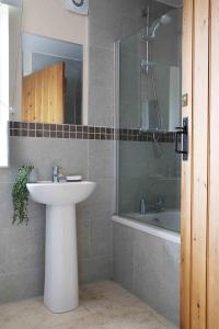 a bathroom with a sink and a shower and a tub at Greenfinch in Lucker