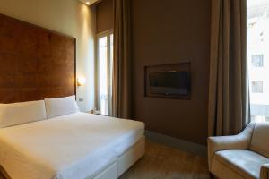 a bedroom with a bed and a couch and a television at Hotel Dei Dragomanni in Venice