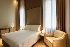 a hotel room with a bed and a chair at Hotel Dei Dragomanni in Venice