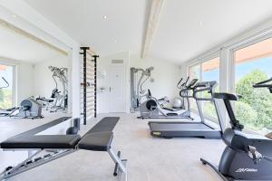 a gym with treadmills and ellipticals in a room with windows at Terre d'Orizon in Tourrettes-sur-Loup
