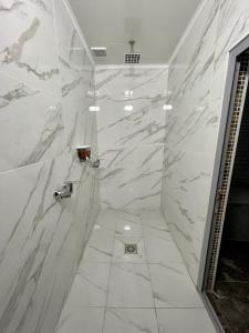a bathroom with white marble walls and a shower at Comfortplace in Atyraū +20 photos