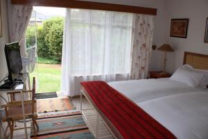 um quarto com uma cama e uma grande janela em Rosewood Corner, Clarens em Clarens