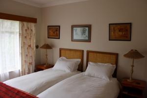 two beds sitting next to each other in a bedroom at Rosewood Corner, Clarens in Clarens