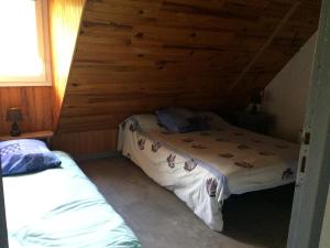 a bedroom with two beds in a log cabin at Appartement dans grange in Aucun