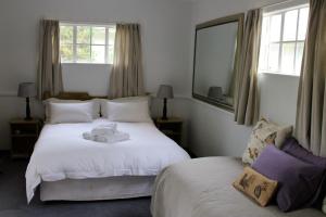 um quarto com 2 camas, um espelho e janelas em Rosewood Corner, Clarens em Clarens