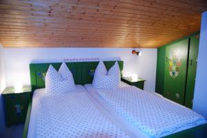 ein Schlafzimmer mit einem Bett mit blauen und weißen Kissen in der Unterkunft Haus Mitterstang in Bischofswiesen