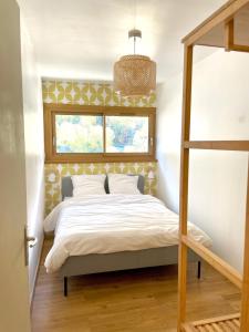 a bedroom with a bed with a window at Les Moutons de Cauterets - garage privé in Cauterets