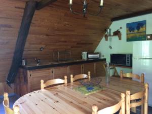 a dining room with a wooden table and a kitchen at Appartement dans grange in Aucun