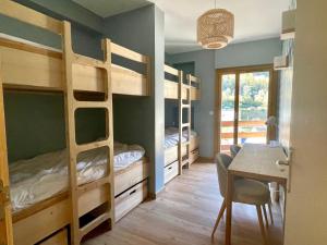 a room with bunk beds and a table and a desk at Les Moutons de Cauterets - garage privé in Cauterets
