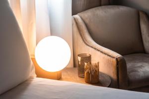 a lamp sitting next to a chair next to a bed at Hotel Dei Dragomanni in Venice