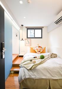 台北的住宿－在家行旅 中山館，一间卧室配有一张带橙色枕头的大床