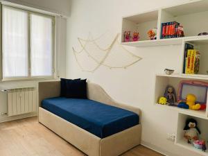 una camera da letto con letto con lenzuola blu e scaffali di Mamidoli apartment, exclusive area in Chiavari a Chiavari