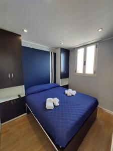 - une chambre avec un lit bleu et des serviettes dans l'établissement La stanza sul Porto di Amalfi camera piccina piccina con bagno privato, à Amalfi