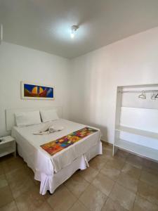 Pousada Nossa Casa في ماسيو: غرفة نوم مع سرير مع بطانية ملونة عليه