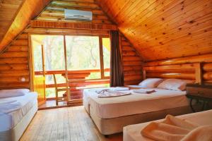 a bedroom with two beds in a log cabin at Woodline Hotel in Kemer