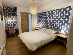 a bedroom with a bed with a blue and white patterned wall at Les Moutons de Cauterets - garage privé in Cauterets