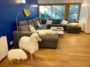 two sheep standing in a living room with a couch at Les Moutons de Cauterets - garage privé in Cauterets