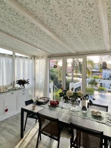 a dining room with a table and some windows at Villa Volli Three Rooms in Agrigento