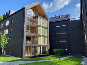ein schwarzes Gebäude mit Balkonen neben einem anderen Gebäude in der Unterkunft APART Resort Schruns in Schruns-Tschagguns