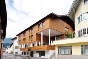 ein Gebäude mit einer Holzfassade auf einer Straße in der Unterkunft Hotel Goldener Adler Wattens in Wattens