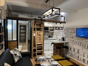 um apartamento loft com um sofá preto e uma cozinha em Loft Jaures em Paris