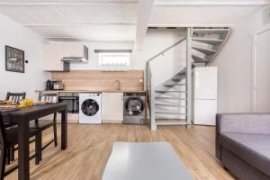 a kitchen and living room with a staircase in a apartment at Maison Manon. maison à la campagne! in Comines