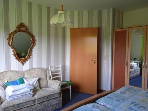 a living room with a couch and a mirror at Ferienwohnung kaub in Immerath