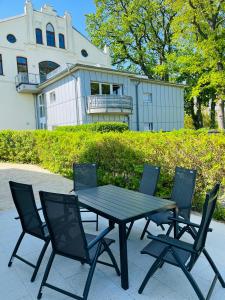 a black table and chairs in front of a building at Ferienwohnung Ostseeblick in Kägsdorf