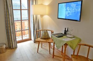 a dining room with a table and a television on the wall at Seewirt Zauner - contactless check in in Hallstatt