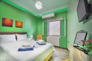 a green bedroom with a bed with towels on it at Seaside House in Kissamos
