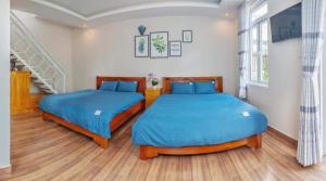 two beds in a room with a staircase at Moonlight Homestay in Da Lat