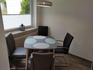 een kleine tafel en stoelen in een kamer met een raam bij Ferienwohnung Bergwiese 20 in Bad Harzburg