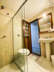 a bathroom with a shower and a toilet and a sink at HOTELARE Hotel Brunello in Paraty