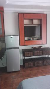 a kitchen with a refrigerator and a tv at Genie's Nest 3 in Pretoria
