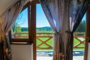 una ventana con vistas a una puerta y al césped en Chata Kasi, en Lutowiska