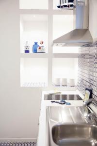 een keuken met witte kasten en een wastafel bij White Blu House - Massa Lubrense Sorrento in Massa Lubrense