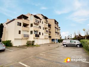 budynek z samochodem zaparkowanym na parkingu w obiekcie Studio 4 couchages piscine , plage , vue canigou w mieście Saint-Cyprien +3 zdjęcia