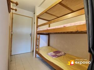 Pokój z 2 łóżkami piętrowymi i drzwiami w obiekcie Studio 4 couchages piscine , plage , vue canigou w mieście Saint-Cyprien