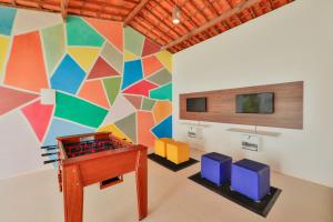 um quarto com uma mesa e uma parede colorida em Pousada Humaitá em Japaratinga