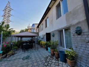 a patio with a table and an umbrella next to a building at Ortachala Summer House in Tbilisi City