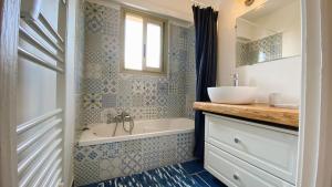 een badkamer met een bad, een wastafel en een bad tubermott bij T2 Bricka La Terrasse de la plage, Moderne, équipé, Lumineux in Antibes