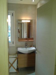 ein Badezimmer mit Waschbecken und Spiegel in der Unterkunft Avia Holiday Homes in Avía
