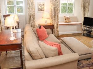 a living room with a couch and a television at Manor Cottage in Cirencester