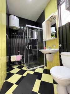 a yellow and black bathroom with a shower and a toilet at Apartmani Tamara in Tivat