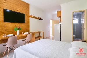 a bedroom with a bed and a desk and a television at Estúdios 3 Praias in Ubatuba