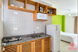 a kitchen with a sink and a refrigerator at Estúdios 3 Praias in Ubatuba