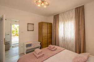 une chambre avec un lit avec des oreillers roses dessus dans l'établissement Apartman Enjoy, à Rovinj