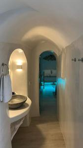 a bathroom with a sink and a hallway at Lamar Cave house in Emporio Santorini