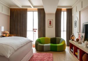 1 dormitorio con 1 cama y 1 silla verde en Sinner Paris en París