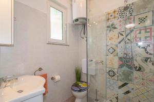 une salle de bain avec une douche, des toilettes et un lavabo dans l'établissement Apartman Enjoy, à Rovinj 23 autres photos
